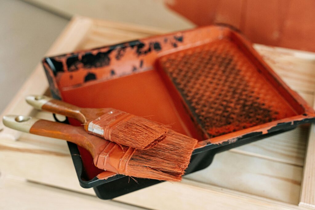 Pinceaux et peinture ocre pour peindre un pot en terre