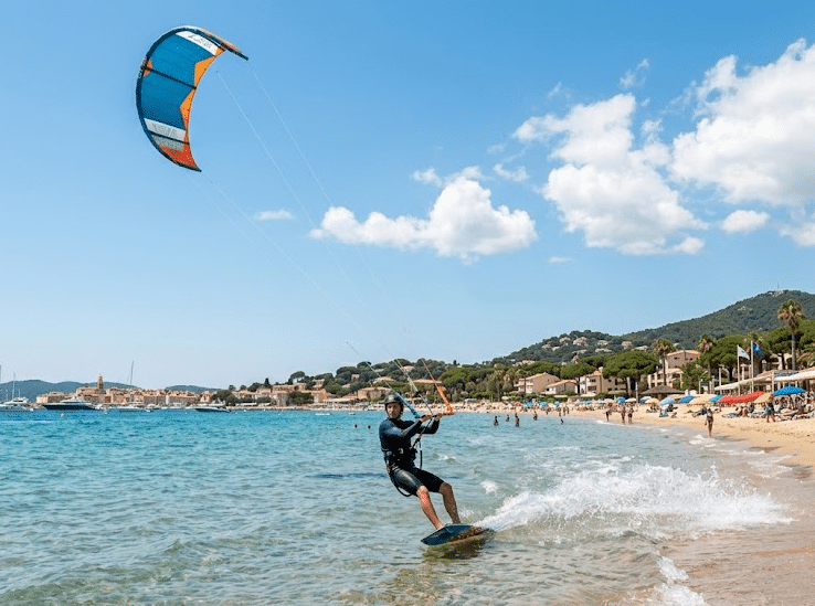 Un kitesurfeur en action glissant sur l'eau transparente de la plage de la Nartelle à Sainte-Maxime